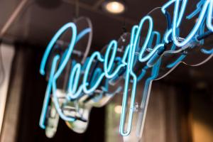 a row of neon signs hanging from a ceiling at Scandic No 53 in Stockholm
