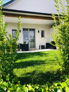 una casa con un patio con césped verde en Bel Air Studios-Terrasse couverte-Jardinet-Vue Pont de Normandie-Parking privé, en Honfleur