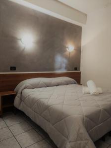 una camera da letto con un letto con due luci sul muro di Hotel Marinoni a Lomazzo