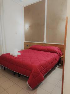 un letto rosso con piumone rosso in camera di Hotel Marinoni a Lomazzo