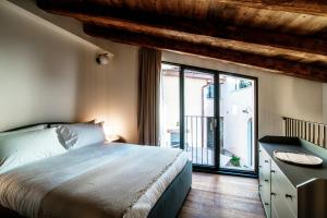 a bedroom with a bed and a large window at Lo Stallino by Quokka 360 - a stone's throw from the Hermann Hesse Museum in Montagnola