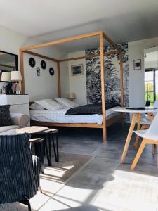 a bedroom with a canopy bed in a room at Bel Air Studios-Terrasse couverte-Jardinet-Vue Pont de Normandie-Parking privé in Honfleur