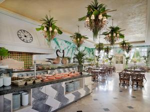 un restaurante con mesas y sillas y un reloj en la pared en Gran Oasis Resort, en Playa de las Américas