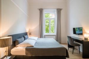 a bedroom with a bed and a desk and a window at Hotel Aurora in Wiesbaden +48 photos
