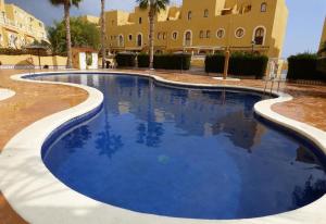 a swimming pool in front of a building at Wonderful house with private beach in El Campello
