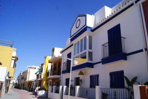 een wit gebouw met een klok aan de zijkant bij Casa López- Lujosa casa de playa en Málaga in Málaga