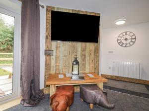 a room with a table and a television on a wall at Stall 2 - The Stables in Truro