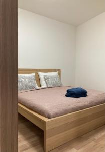 1 dormitorio con 1 cama con marco de madera en ELIXÍR Apartman Pécsvárad, en Pécsvárad