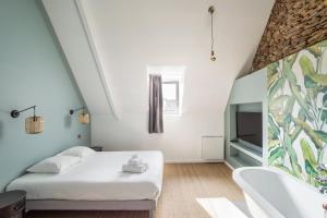 LA PILOTINE - maison 2 chambres في سان كولوم: غرفة نوم مع سرير وحوض استحمام ومغسلة