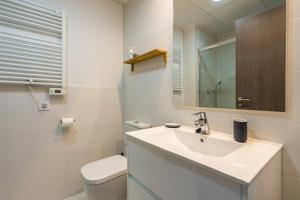 un bagno con lavandino, WC e specchio di Palmera a San Juan de los Terreros Altre 21 foto