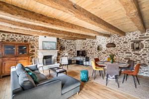a living room with a stone wall at LA PILOTINE - maison 2 chambres in Saint-Coulomb