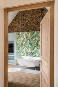a bath tub in a bathroom with a wall at LA PILOTINE - maison 2 chambres in Saint-Coulomb
