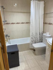 a bathroom with a toilet and a shower curtain at Mijas Playa Retreat in La Cala de Mijas