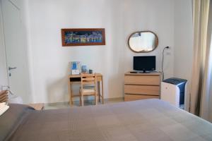 1 dormitorio con cama, mesa y espejo en Sunrise Apartment en Santa Margherita Ligure