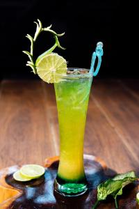 a drink with a slice of lime on a table at Qualia Resort Phu Quoc in Phú Quốc