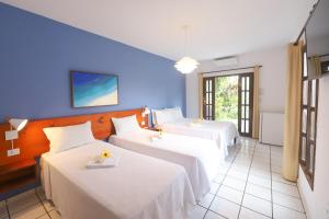 two beds in a room with blue walls at Pousada Arriba Pipa in Pipa +45 photos