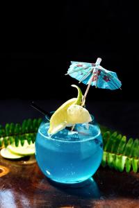 a blue drink with an umbrella and a lizard in it at Qualia Resort Phu Quoc in Phú Quốc