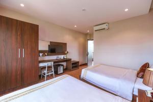 a hotel room with a bed and a desk at Qualia Resort Phu Quoc in Phú Quốc