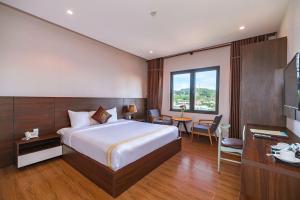 a hotel room with a bed and a desk at Qualia Resort Phu Quoc in Phú Quốc