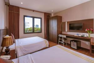 a hotel room with two beds and a desk at Qualia Resort Phu Quoc in Phú Quốc