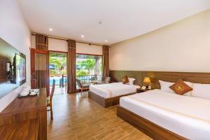 a hotel room with two beds and a desk at Qualia Resort Phu Quoc in Phú Quốc