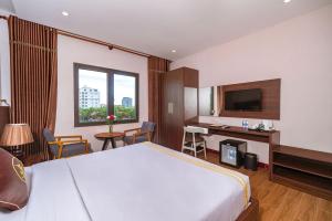a hotel room with a large bed and a desk at Qualia Resort Phu Quoc in Phú Quốc