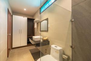 a bathroom with a toilet and a sink and a shower at Qualia Resort Phu Quoc in Phú Quốc