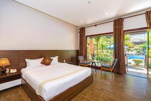 a bedroom with a bed and a view of a pool at Qualia Resort Phu Quoc in Phú Quốc