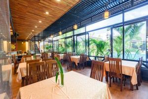 a restaurant with tables and chairs and large windows at Qualia Resort Phu Quoc in Phú Quốc