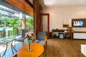 a living room with a vase of flowers on a table at Qualia Resort Phu Quoc in Phú Quốc