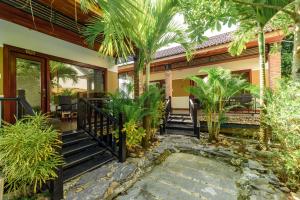 a home with palm trees and a walkway at Qualia Resort Phu Quoc in Phú Quốc +37 photos