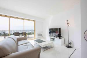 sala de estar blanca con sofá y TV en Luxury penthouse breathtaking sea view 200m2 terrace in the Cannes center, en Cannes