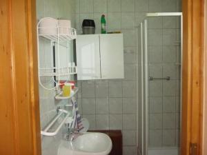 uma casa de banho com um lavatório e um chuveiro em Barbara Apartmanház em Kehidakustány