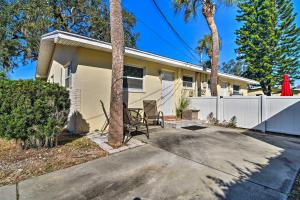 a house with a white fence and palm trees at Comfy Dunedin Escape 1 Block to Main Street! in Dunedin