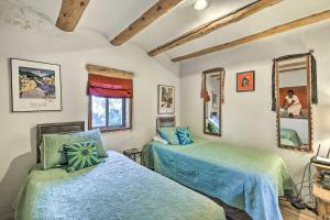 Un dormitorio con dos camas y dos espejos. en El Prado Home with Hot Tub, Panoramic Mtn Views, en El Prado