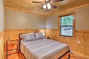 1 dormitorio con 1 cama y ventilador de techo en Silver Creek Cabin with Hiking, Less Than 1 Mi to Town! en Beattyville