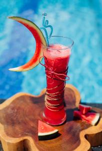 a drink in a glass with a slice of fruit at Qualia Resort Phu Quoc in Phú Quốc