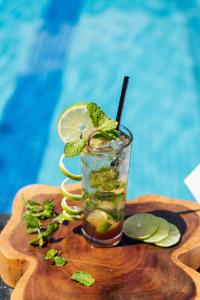 a drink with lime and mint on a cutting board at Qualia Resort Phu Quoc in Phú Quốc