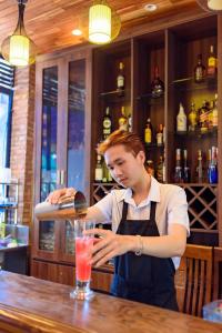 a man standing at a bar making a drink at Qualia Resort Phu Quoc in Phú Quốc