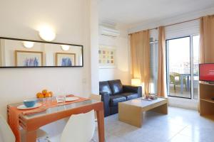 a living room with a couch and a table at Apartamentos Calvet in Barcelona