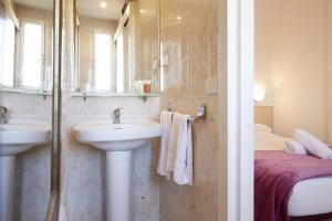 a bathroom with a sink and a mirror and a bed at Apartamentos Calvet in Barcelona
