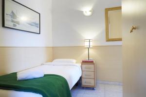 a bedroom with two beds and a nightstand and a mirror at Apartamentos Calvet in Barcelona