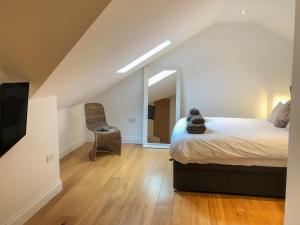 a bedroom with a bed and a mirror and a chair at The Hideaway in St Ives