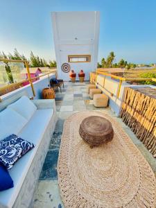 a patio with a white couch and a large hat at Pousada Sole - D3 Experience - Preá, CE in Prea