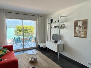 a living room with a red couch and a television at Les Suites du Port in Le Bourget-du-Lac