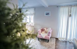 uma sala de estar com uma cadeira rosa e uma árvore de Natal em Ferienwohnung Marianne Ortszentrum für Familien 180qm em Berchtesgaden