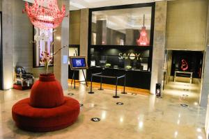 eine Lobby mit einem roten Stuhl und einem Kronleuchter in der Unterkunft Savoy Hotel in Buenos Aires