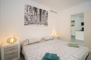 biała sypialnia z łóżkiem i zdjęciem na ścianie w obiekcie Flamingo playa 8 w mieście San Pedro del Pinatar