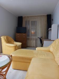 a living room with two yellow couches and a table at Ultracentral Armeneasca street Chisinau in Chişinău