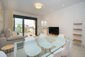 a living room with a glass table and white chairs at Champan in La Mata